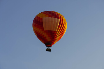 red orange hot air balloon at sunrise flying with mountains line behind minimalist