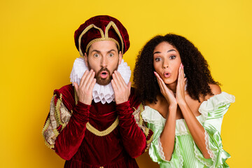 Couple dressed in elegant historical costumes sharing a surprise expression against a vibrant yellow background