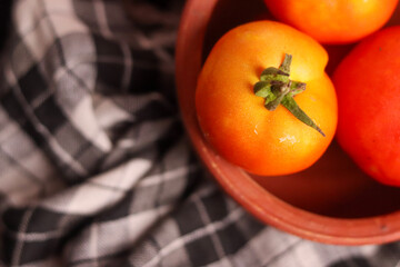 Fresh red tamotoes with kitchen cloth and kept in a bowl, healthy vegetable in the kitchen