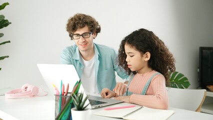 American daughter learning to coding and writing engineering prompt while positive smart father...