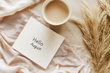 Hello august greeting card with coffee and dry plants on wooden table