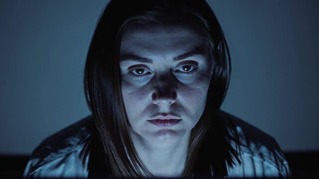 Femme fatigu&eacute;e fixant un &eacute;cran dans l&rsquo;obscurit&eacute;, ambiance num&eacute;rique froide et silencieuse

