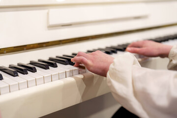 Musician creates beautiful melody on a white piano during a cozy indoor session