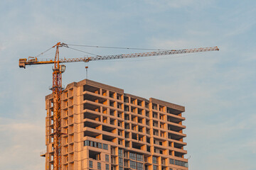 A photograph showcases an early-phase construction of a multi-story building, with steel reinforcement and concrete columns, under soft-clouded sky, potentially at dawn or dusk It could be used in r