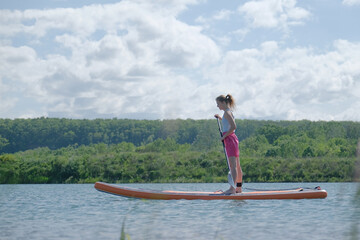 Naklejka premium happy woman rowing sup board on river water , paddleboard and surfing