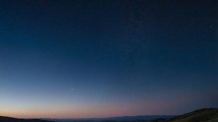 Fototapeta premium Beautiful Twilight Skyline Reveals Stars Above Distant Mountains During Clear Evening in a Serene Rural Area