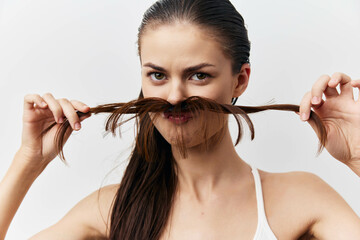 girl playing with hair, funny expression, creative pose, close up shot on neutral background,...