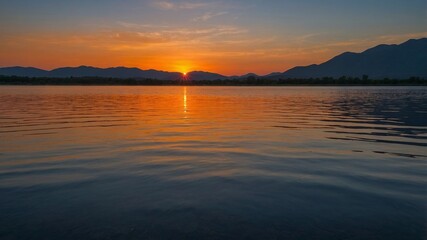 Fototapeta premium Stunning Sunset Over Calm Lake With Vibrant Colors Reflecting on the Water, Framed by Mountains at Dusk in a Serene Natural Landscape