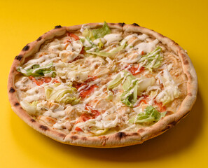 Italian caesar pizza with cheese and chicken, lettuce leaves and sauce