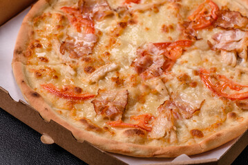 Italian pizza with chicken and bacon, cheese, tomatoes and sauce
