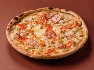 Italian pizza with chicken and bacon, cheese, tomatoes and sauce