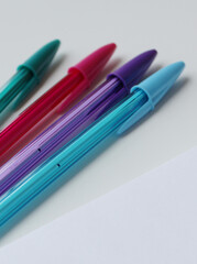 Set of four cool color ballpoint pen and blank paper page. Ideal for writing, study, creativity, education and back to school themes. Colorful stationery, office supplies.
