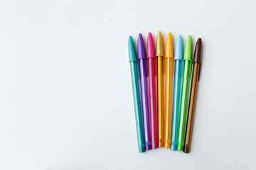 Set of rainbow color ballpoint pens, side by side, on clean white background. Ideal for kids education, art lesson, creative work, colorful design. Ample copy space for advertisement.