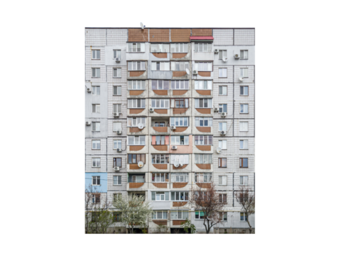 Nine-storey apartment building with enclosed balconies and air conditioning units is isolated. 1980s residential prefabricated building with tiled facade and satellite dishes.