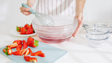 Mixing strawberry base in a bowl to prepare jelly.
