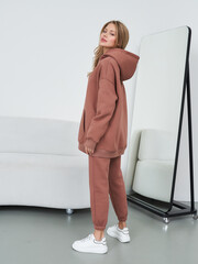 Female model poses in stylish loungewear in studio setting with minimalist decor