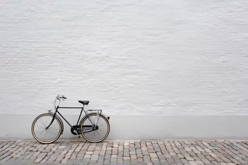 Fototapete Rund Simple bicycle parked beside a whitewashed brick wall. © yusilva