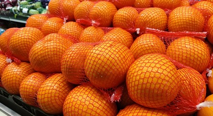 Fototapeta premium Pile of Grapefruit in Red Netting