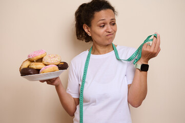 Woman Contemplating Donuts While Holding a Measuring Tape in a Health and Wellness Concept