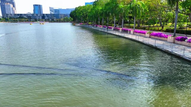 Aerial: Drone Forward Shot Of Rippled Lake Ratchada In Modern City - Bangkok, Thailand