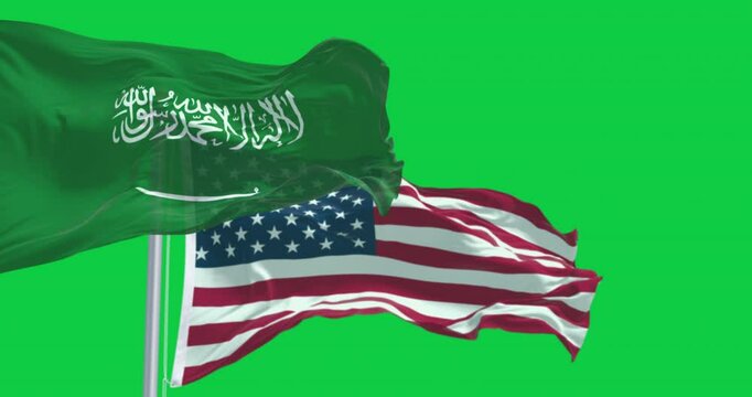 Flags of Saudi Arabia and The US waving in the wind isolated on green background