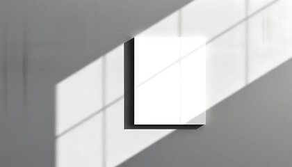 Empty white vertical rectangle poster or business card mockup with diagonal window shadow on the smooth gray concrete wall.Flat lay, top view. Open composition, dramatic. White tone