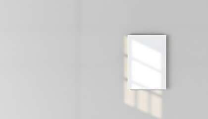 Empty white vertical rectangle poster or business card mockup with diagonal window shadow on the smooth gray concrete wall.Flat lay, top view. Open composition. White tone