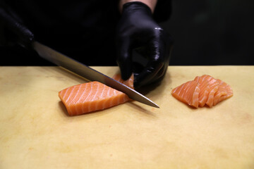 chef experto en cortar pescado crudo para elaborar sushi con salmón ahumado