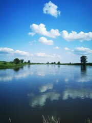 A serene ocean view with calm waters reflecting the blue sky and scattered white clouds