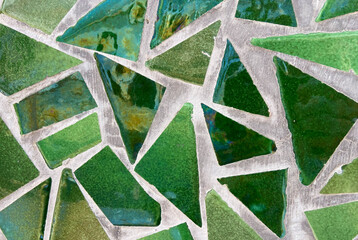 Broken tiles mosaic made with green white ceramic pieces background texture for design.Colorful...