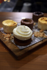 pastel muffins artesanal de chocolate con crema y nata en una tabla de repostería