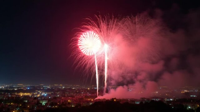 Bright fireworks exploding over a city at night, Large colorful fireworks lighting up the sky above the city