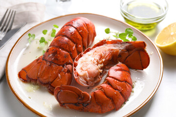 Delicious tails of boiled lobsters served on white table, closeup