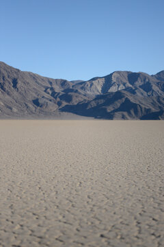 Racetrack Playa cracked dried lake bed with mountains and blue sky