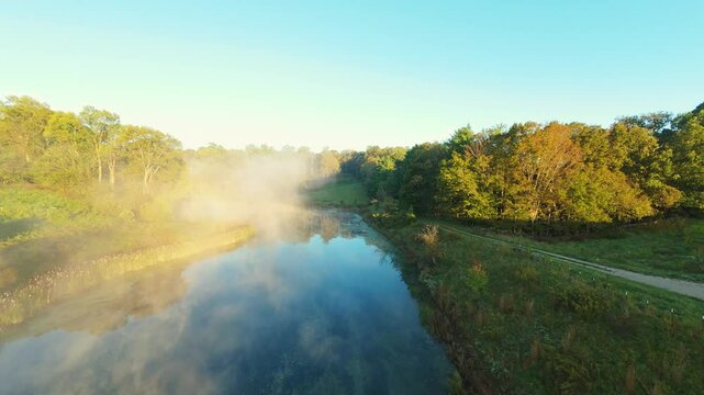Golden sunrise illuminating misty river and green trees in Johnson City Tennessee USA