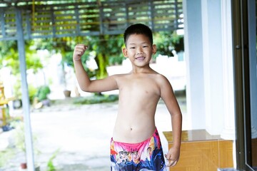 A shirtless boy shows off his slightly muscular build and enjoys a summer day.