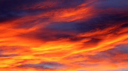 Fototapeta premium Vibrant orange and purple clouds illuminated by sunset light in a tranquil sky, with a soft blurred background creating a dreamy atmosphere that highlights the vivid colors natural beauty of the scene