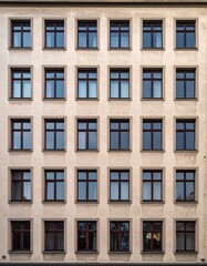 Fototapeta premium 縦に一直線に並ぶ正方形窓が映える伝統的古い住宅のシンメトリックなファサード