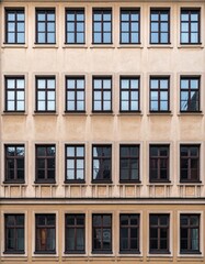 Fototapeta premium 縦に一直線に並ぶ正方形窓が映える伝統的古い住宅のシンメトリックなファサード