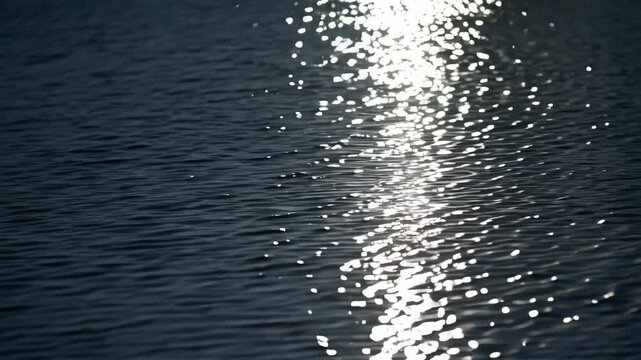 Sunlight reflected on the surface of water creating glittering patterns and shimmering light spots, creating mesmerizing visual textures.