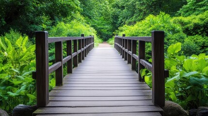 Fototapeta premium A beautiful wooden bridge surrounded by lush greenery, leading into a tranquil park or nature reserve.