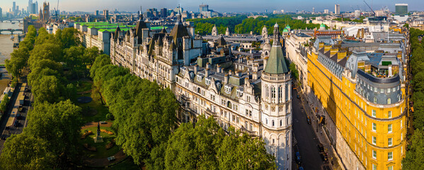 Panoramic aerial view of central London featuring the River Thames, Hungerford Bridge, Charing Cross Station, and iconic landmarks on a sunny day