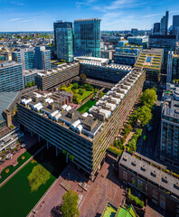 Colorful aerial view of London's Barbican Estate with high-rise buildings, modern architecture, and city skyline under a blue sky