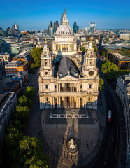 Aerial view of St. Paul’s Cathedral in London with surrounding cityscape under clear blue skies