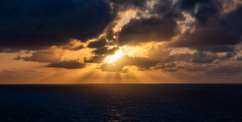 Dramatic Sunset Over the Ocean with Clouds and Sun Rays