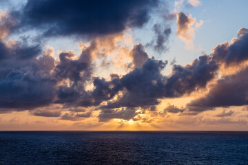 Obraz premium Colorful Sunset Over Ocean Horizon with Dramatic Cloudscape