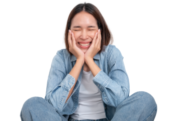 A portrait of young Asian female wear blue jean are sitting on ground with smile cheerful face isolate on white
