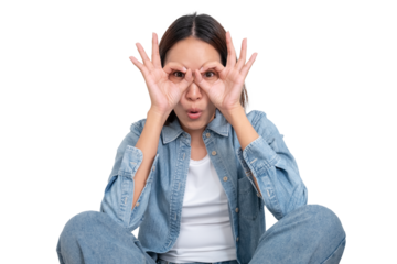 A portrait of young Asian female wear blue jean and make her hands into a glasses shape isolate on white