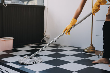 Female janitor with vacuum cleaner in room.