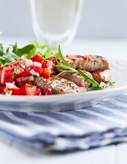 Fried pork tenderloin with tomato salsa. Bright background. Close up.	